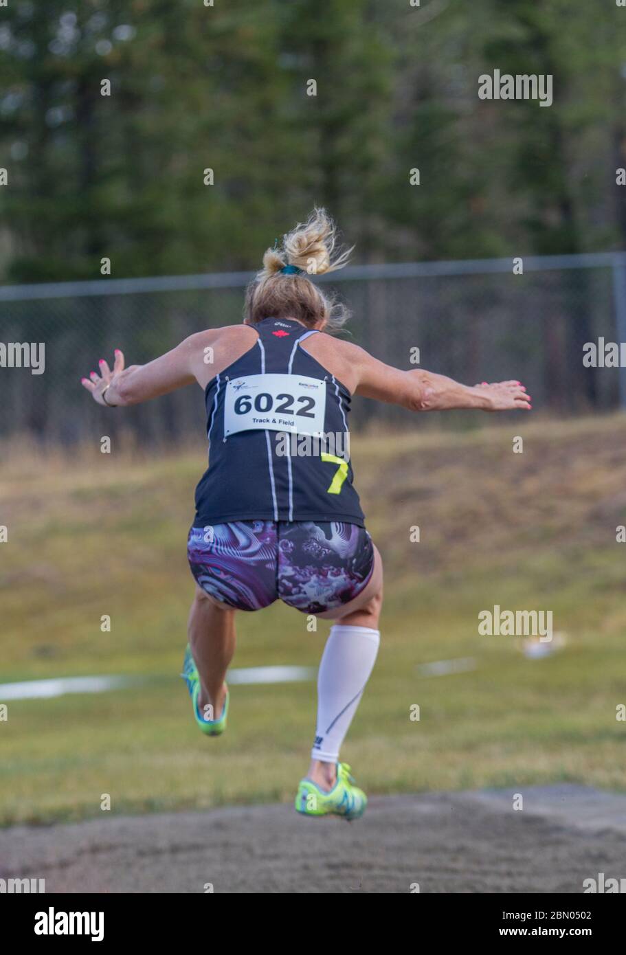 Senior ladies, long jump competition. 60 year old female landing. Shot