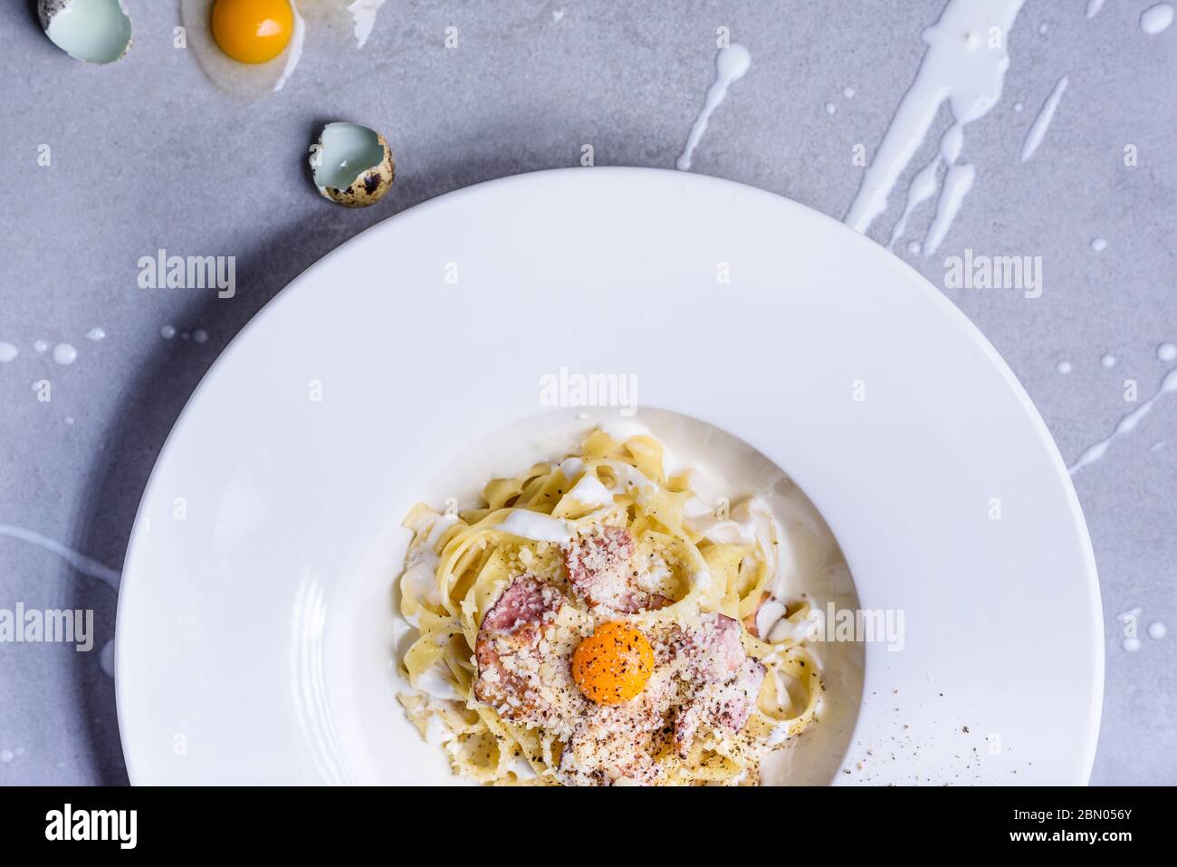 Pasta carbonara with quail egg, plate full of Italian tagliatelle with