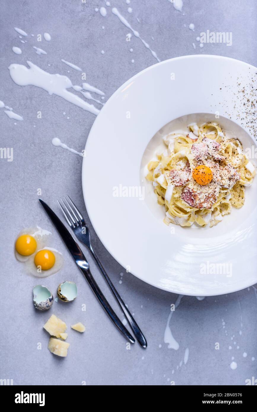 Pasta carbonara with quail egg, plate full of Italian tagliatelle with ham  and cheese. Top view, grey background Stock Photo - Alamy