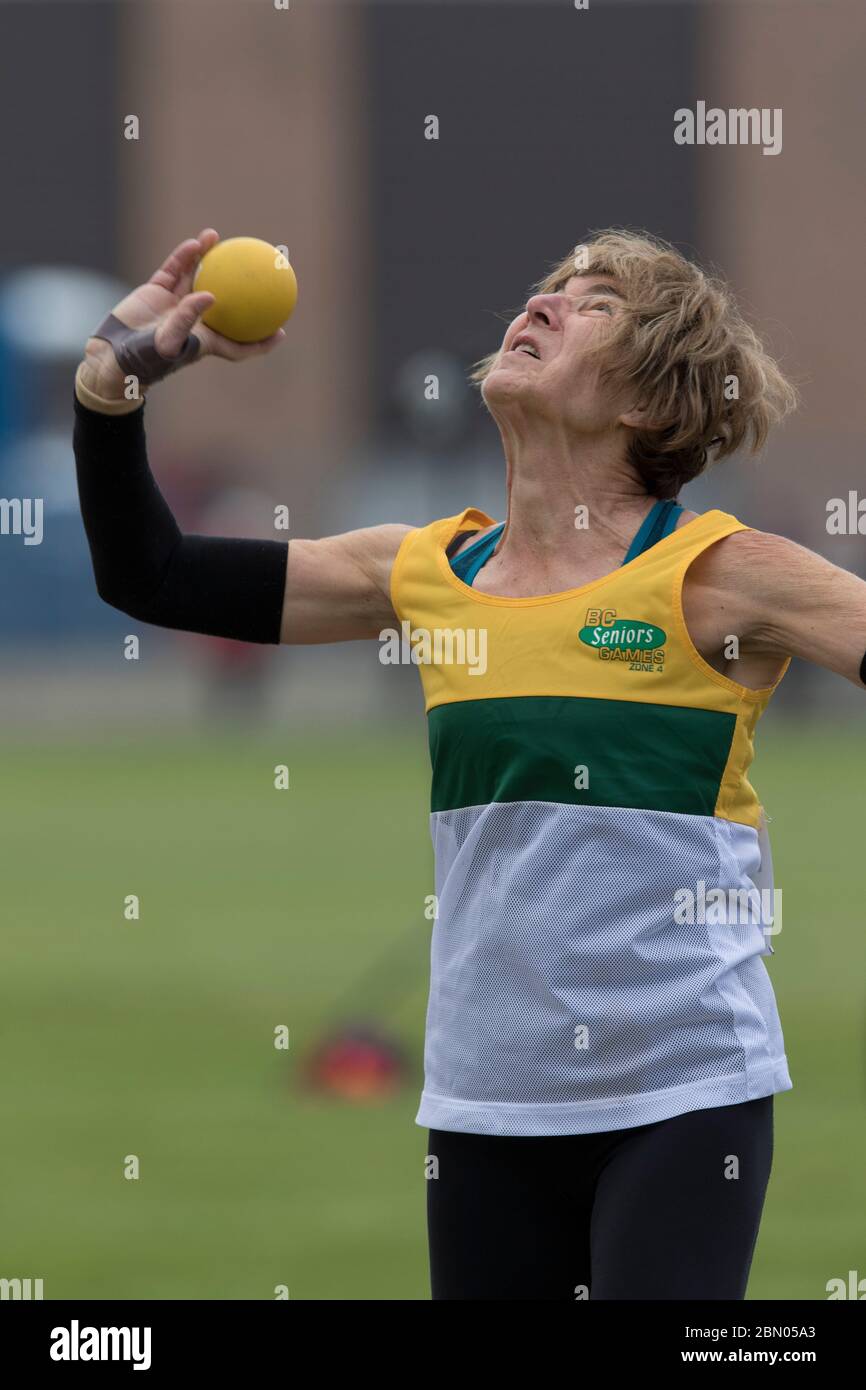 Senior Ladies shot put competition. Just about to release shot put in 70 year old age group. Stock Photo
