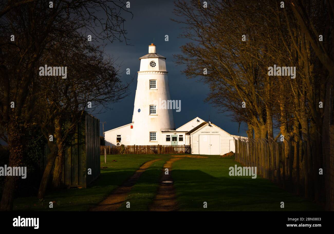 Winter sunlight falling on East Bank Lighthouse famous for The Snow Goose, against a stormy sky in Sutton Bridge, River Nene, Spalding, Lincolnshire Stock Photo