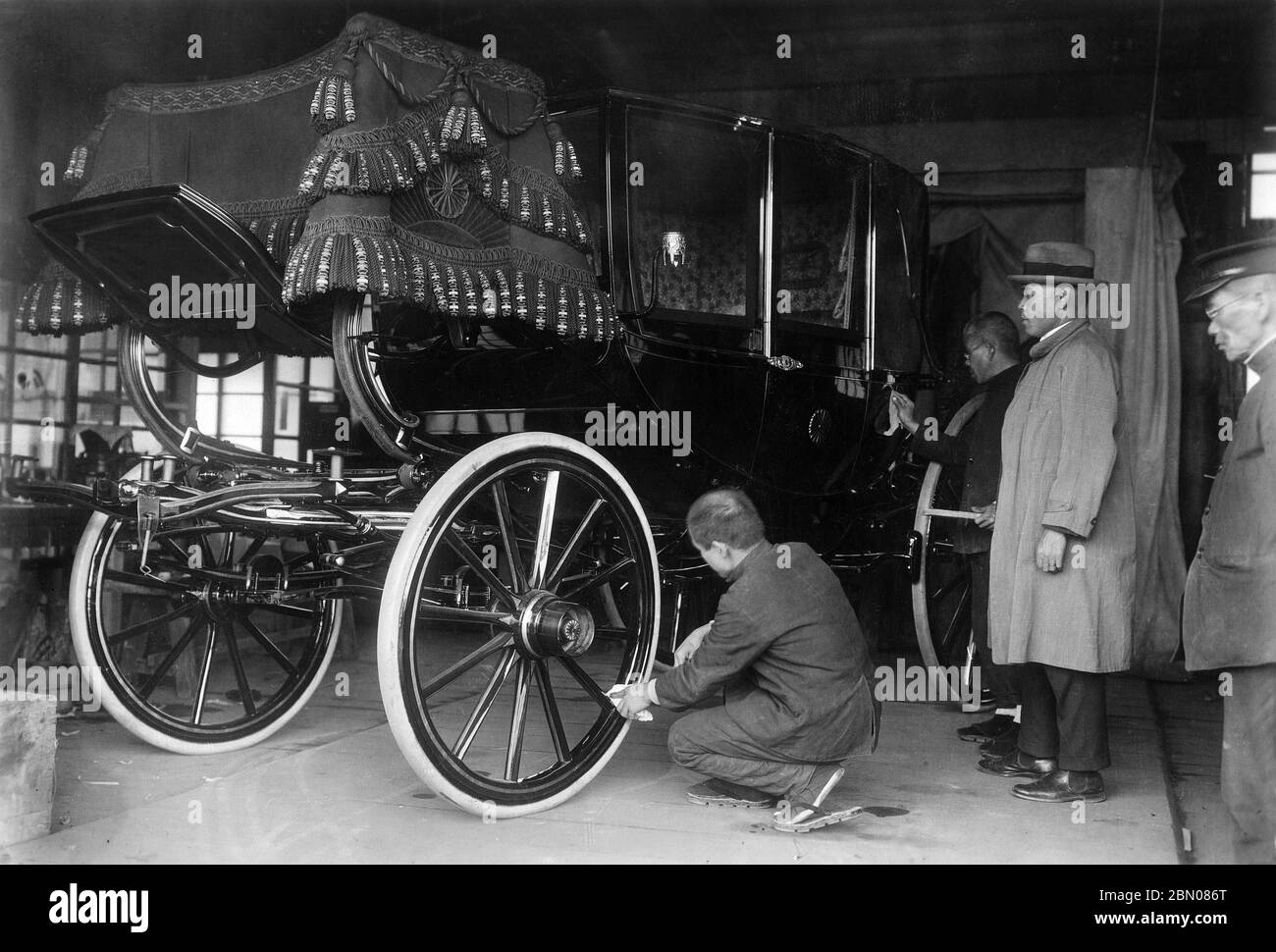 [ 1927 Japan - Imperial Funeral Preparations ] —   Men look on as a carriage is getting prepared for Emperor Taisho's funeral, January 1927 (Showa 2).  Emperor Taisho died of a heart attack on December 25 1926 (Taisho 15).  His funeral, held at night, consisted of a 6 kilometer long procession along a route lit with wood fires in iron lanterns. Some 20,000 mourners followed an ox-drawn cart containing the imperial coffin.  20th century gelatin silver print. Stock Photo