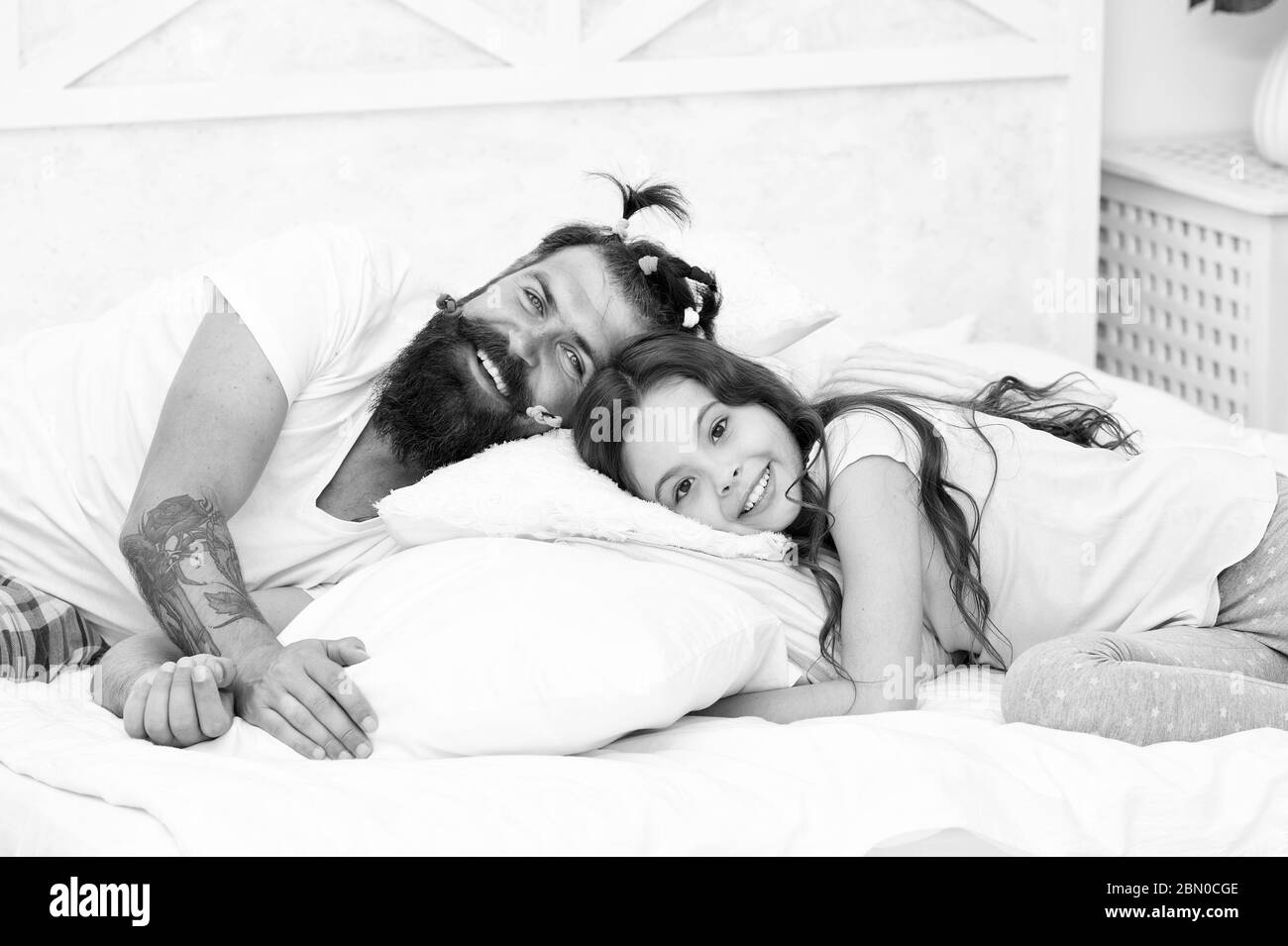 Enjoy better sleep at night. Bearded man put daughter to sleep. Tired child and father go to sleep. Bedtime routine. Got ready for bed. Good night. Sleep well. Stock Photo