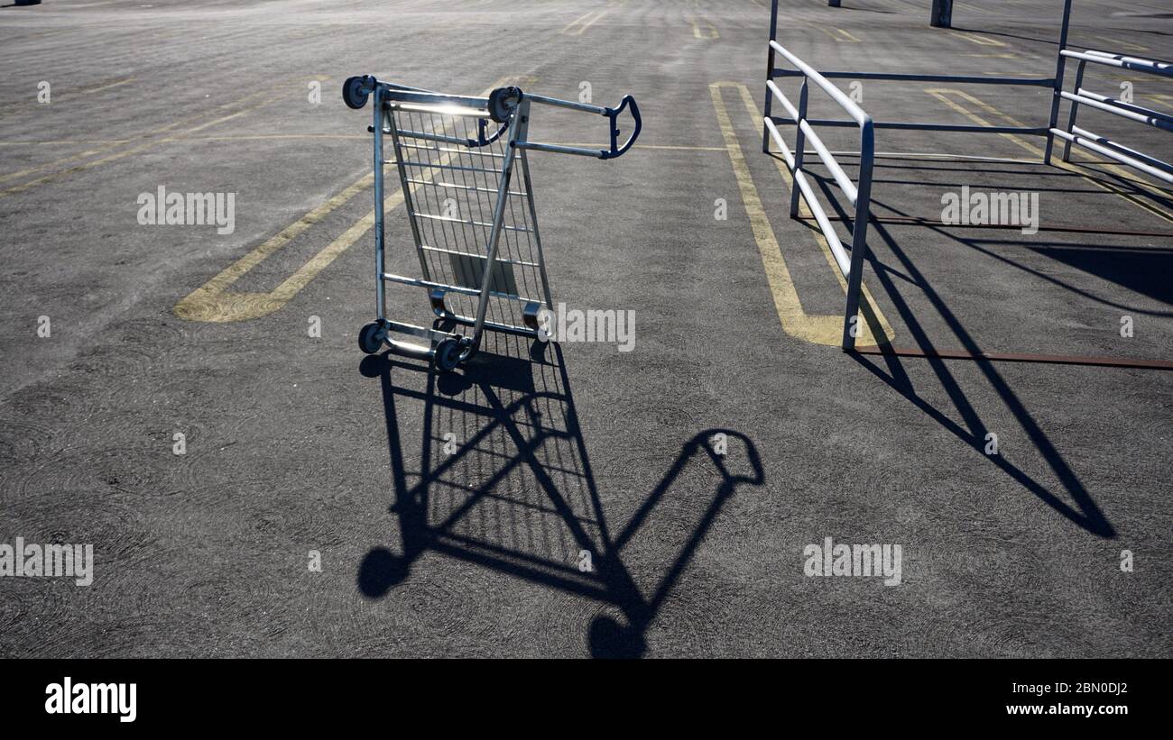 Upturned furniture cart in empty IKEA parking lot during COVID19 coronavirus shutdown, symbol of economic recession and collapse. Emeryville, CA, USA Stock Photo