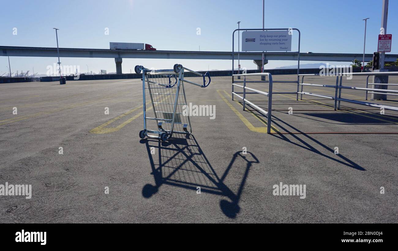 Upturned furniture cart in empty IKEA parking lot during COVID19 coronavirus shutdown, symbol of economic recession and collapse. Emeryville, CA, USA. Stock Photo