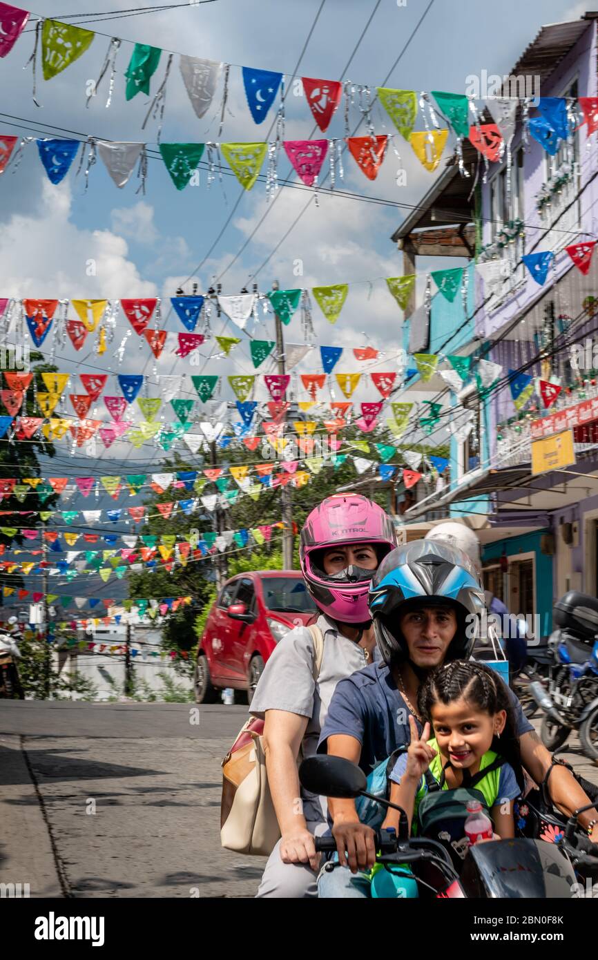 Hispanic family riding motorbike on streets in Cali Colombia Stock Photo