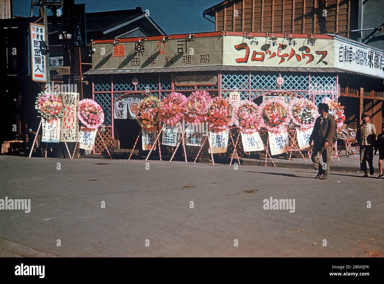 [ 1950s Japan - Celebrating the Opening of a New Restaurant ] —   Colorful wreaths celebrating the opening of a new restaurant (開店祝いの花輪), 1950s.  The restaurant is called called Croquette House (コロッケハウス) and offers Western style food.  20th century vintage slide film. Stock Photo