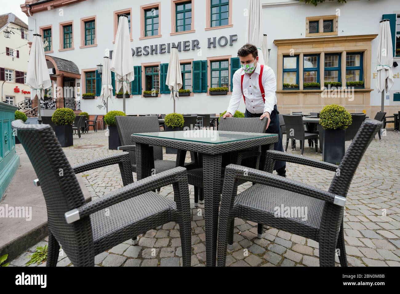 Deidesheim, Germany. 09th May, 2020. An employee places chairs at a table outside in front of the restaurant and hotel 'Deidesheimer Hof'. (to dpa 'Partition walls and flutter band - restaurants and pubs in starting blocks') Credit: Uwe Anspach/dpa/Alamy Live News Stock Photo