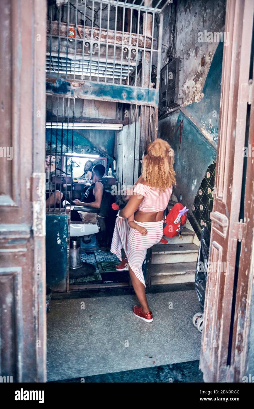 Traditional Cuban Office workshop of barber, watch master in elevator of entrance in residental building converted into a workshop of shoes and woman Stock Photo