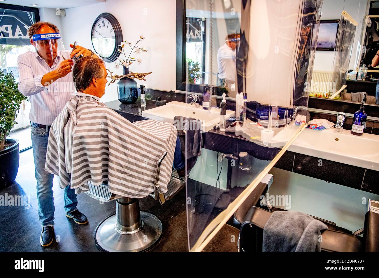 Rotterdam, Netherlands. 11th May, 2020. Ramon Brakman of Kap salon at the Westersingel cuts a clients hair on the first day that salons and barbershops were permitted to reopen amid the coronavirus pandemic. Credit: SOPA Images Limited/Alamy Live News Stock Photo