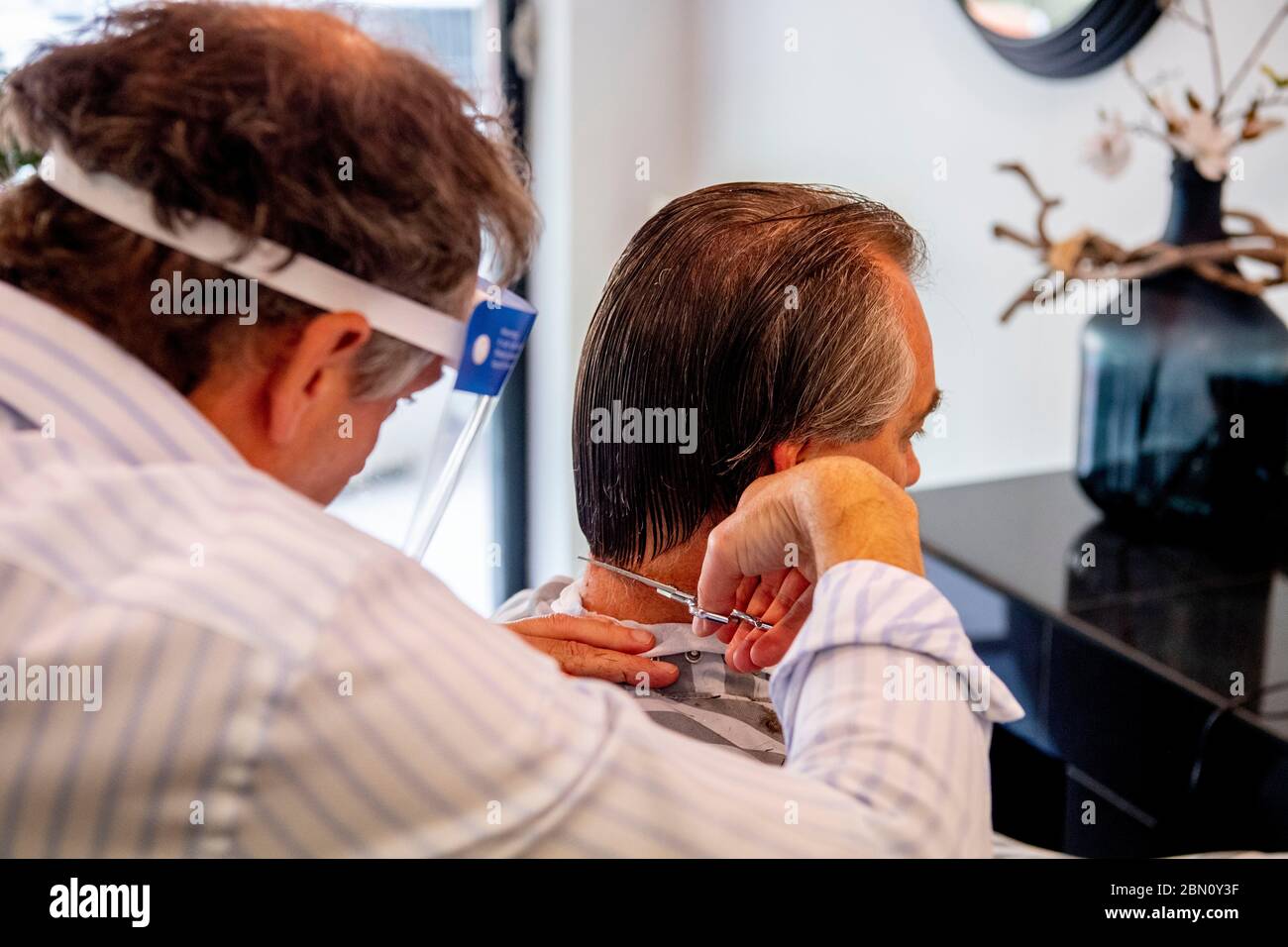 Rotterdam, Netherlands. 11th May, 2020. Ramon Brakman of Kap salon at the Westersingel cuts a clients hair on the first day that salons and barbershops were permitted to reopen amid the coronavirus pandemic. Credit: SOPA Images Limited/Alamy Live News Stock Photo
