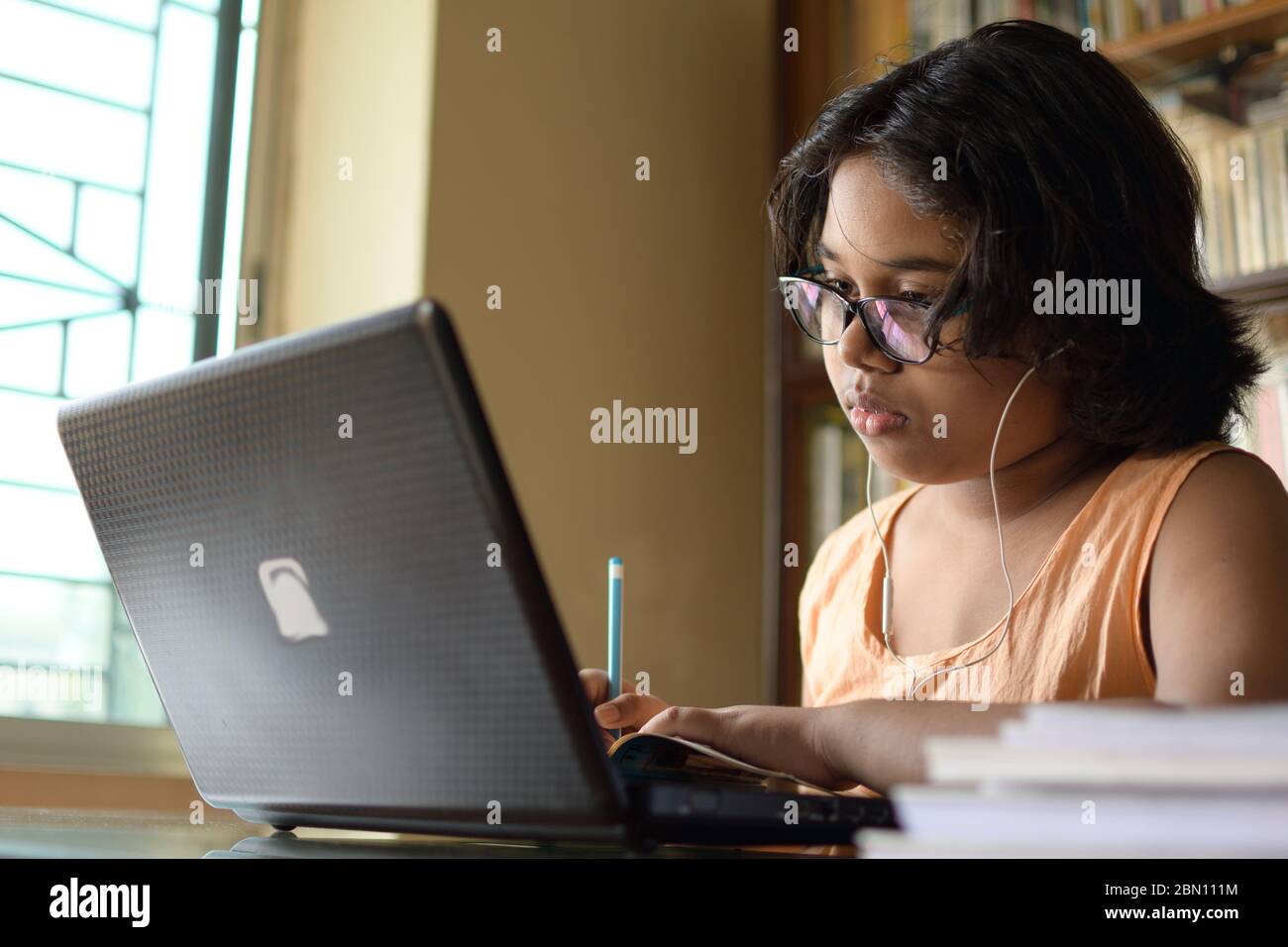 Indian School girl is attending her online class during her stay at home in lock down period due to Corona virus (COVID-19) pandemic. Stock Photo