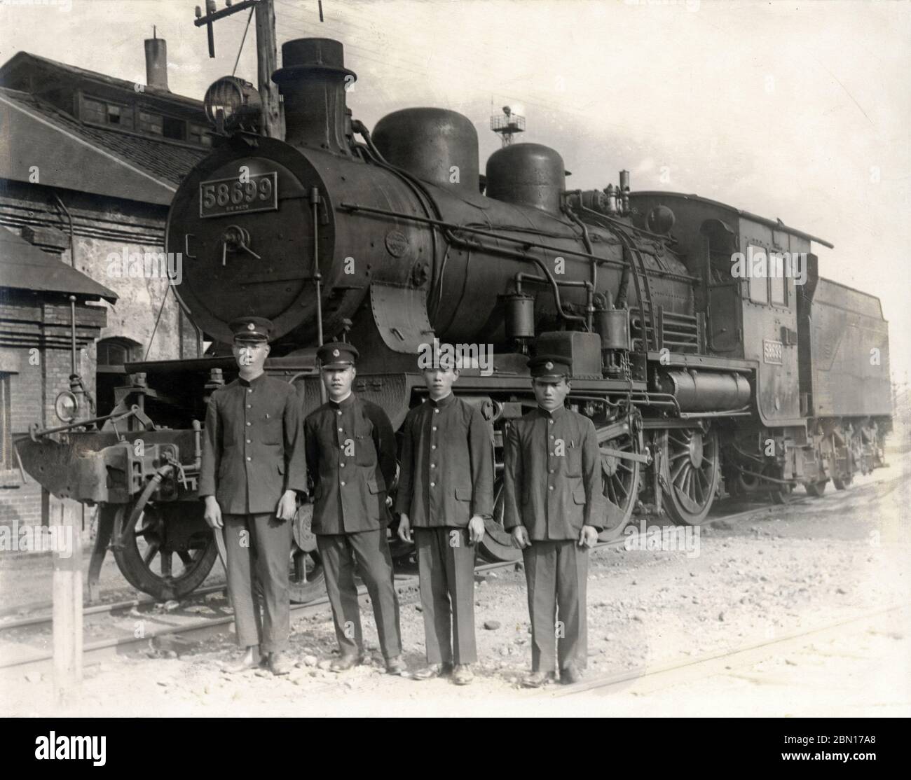 [ 1931 Japan - Imperial Train ] —   Commemorative photo of railway workers in front of a Class 8620 (8620形) steam locomotive with the number 58699.  The photo is dated August 12, 1931 (Showa 6). According to the photo’s caption, the locomotive was used to pull the imperial train of Takahito, Prince Mikasa (三笠宮崇仁親王, 1915–2016).  20th century vintage gelatin silver print. Stock Photo