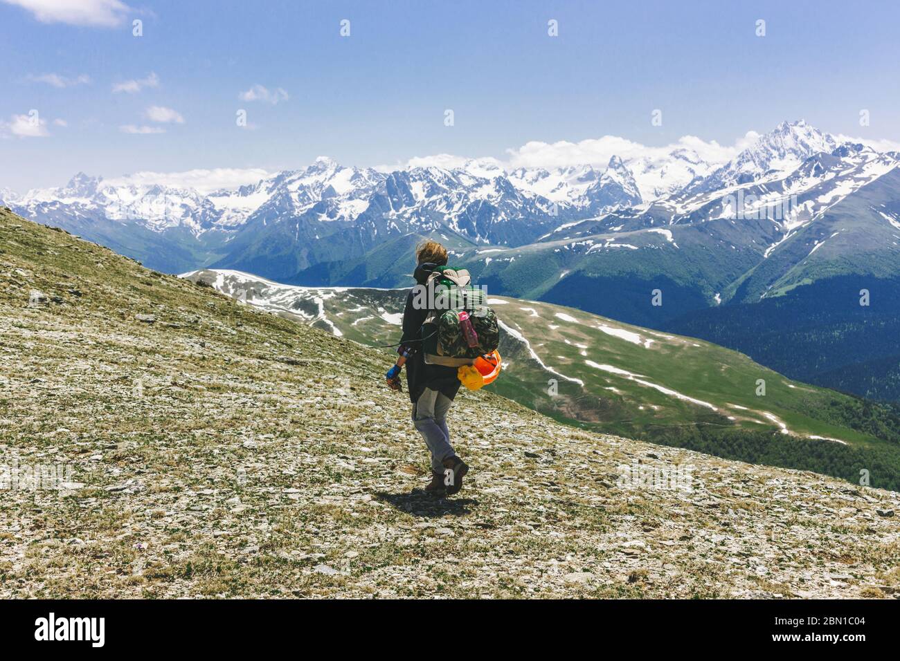 Rear View of a female hiker with a backpack standing on top of the ...