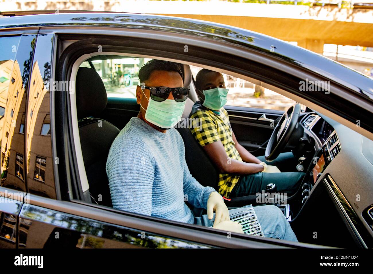 An instructor and a student wear face mask as a preventive measure during the driving lesson on the first day that schools were permitted to reopen amid the coronavirus crisis.The Dutch government eases their coronavirus containment, allowing students to go back to school part time with strict safe and medical measure put across to stop the spread of coronavirus. Stock Photo