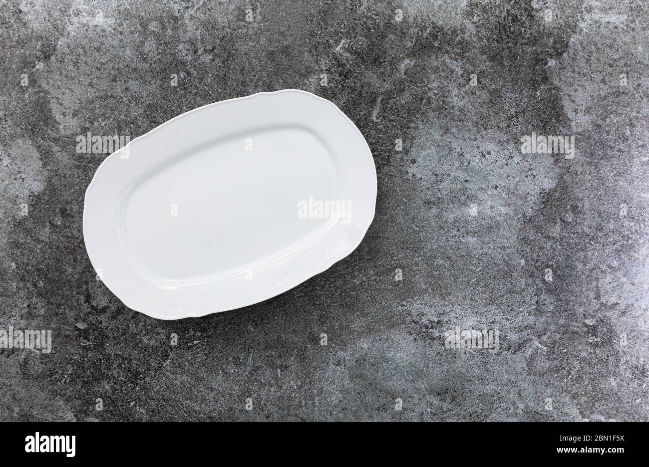 empty white service plate on a grey marble table Stock Photo