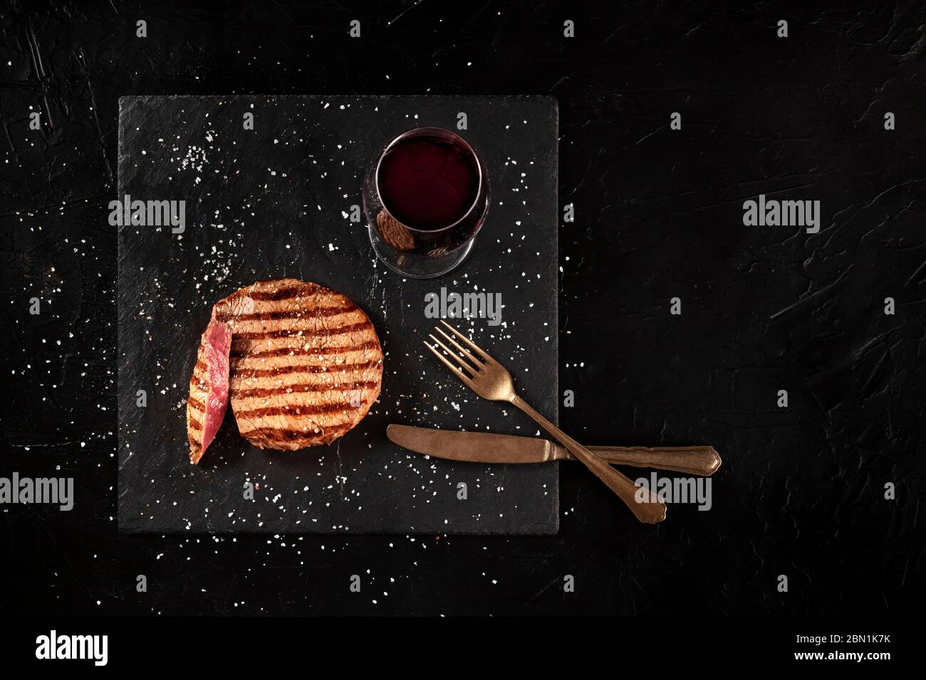 Grilled wagyu beef steak with red wine, shot from above on a black