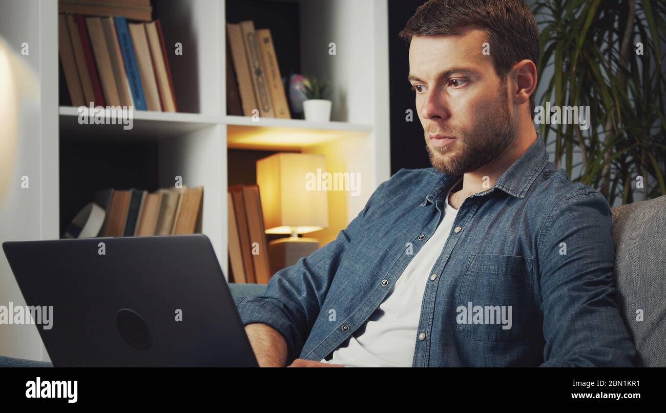 Man using laptop sitting couch Stock Photo