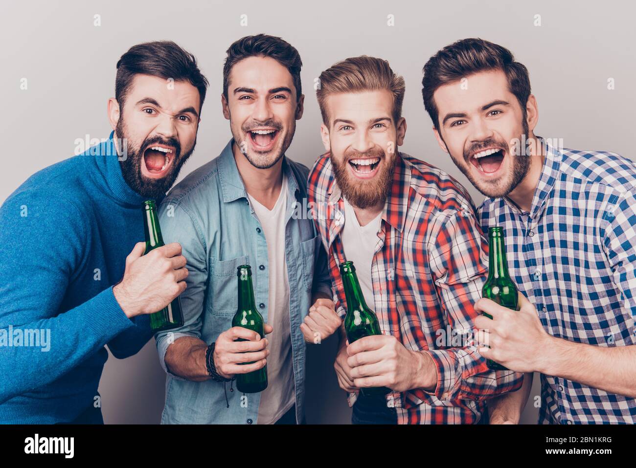 Men`s club. Four crazy friends guys are screaming with bottles in ...