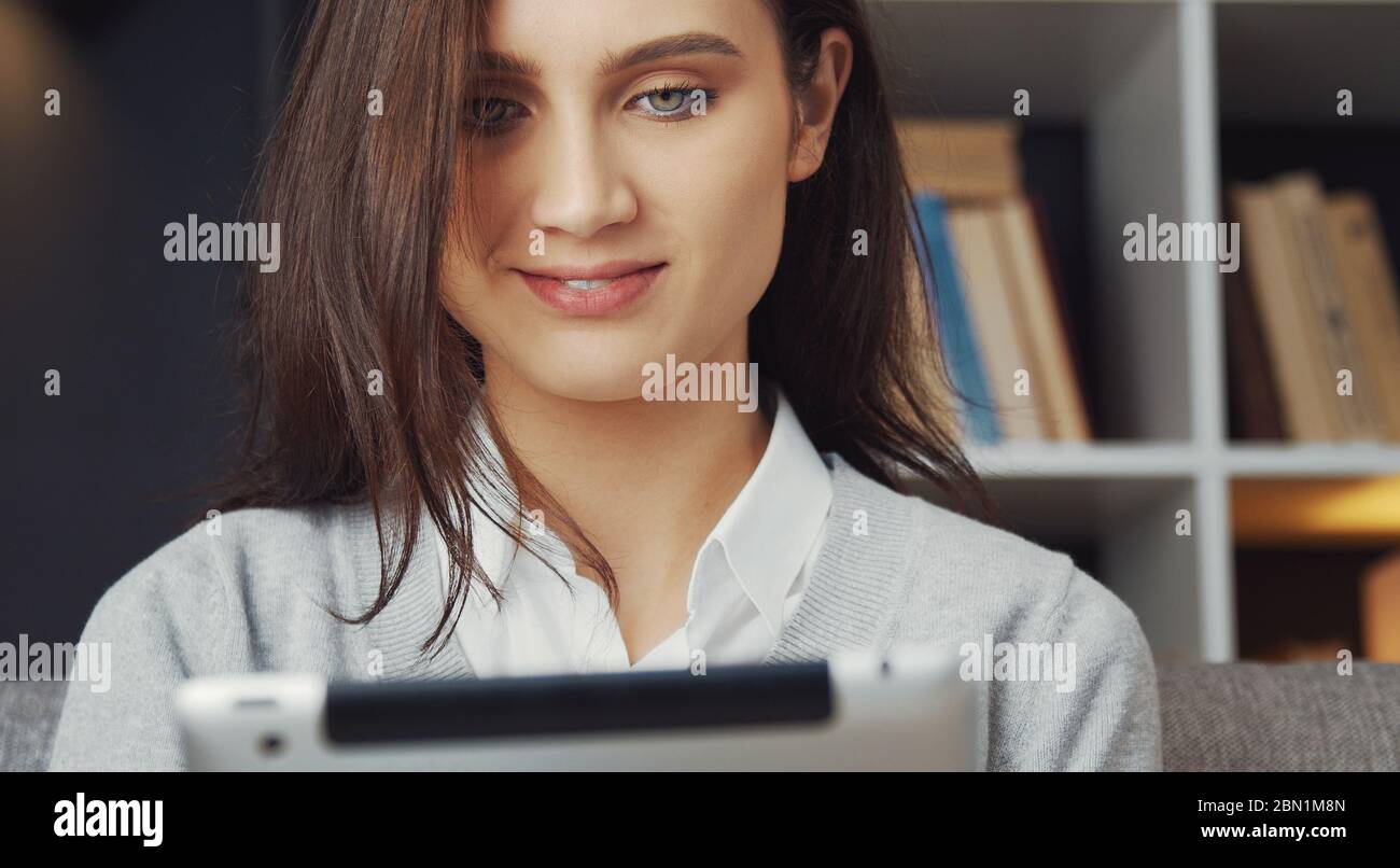 Brunette using tablet indoors, headshot Stock Photo