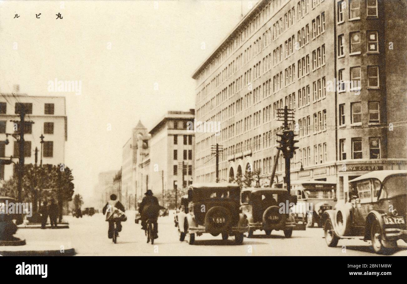 [ 1930s Japan - Marunouchi Building ] —   Traffic in front of the Marunouchi Building (丸ビル, Maru Biru) in Marunouchi in Tokyo. The building was designed by Kotaro Sakurai and opened in 1923, just before the earthquake devastated the city.  It was Japan’s very first office building, and with 371 offices the largest office building in Asia. Maru Biru was replaced by a 37-story building in 2002. The location is now among the most expensive real estate in Japan.  20th century vintage postcard. Stock Photo