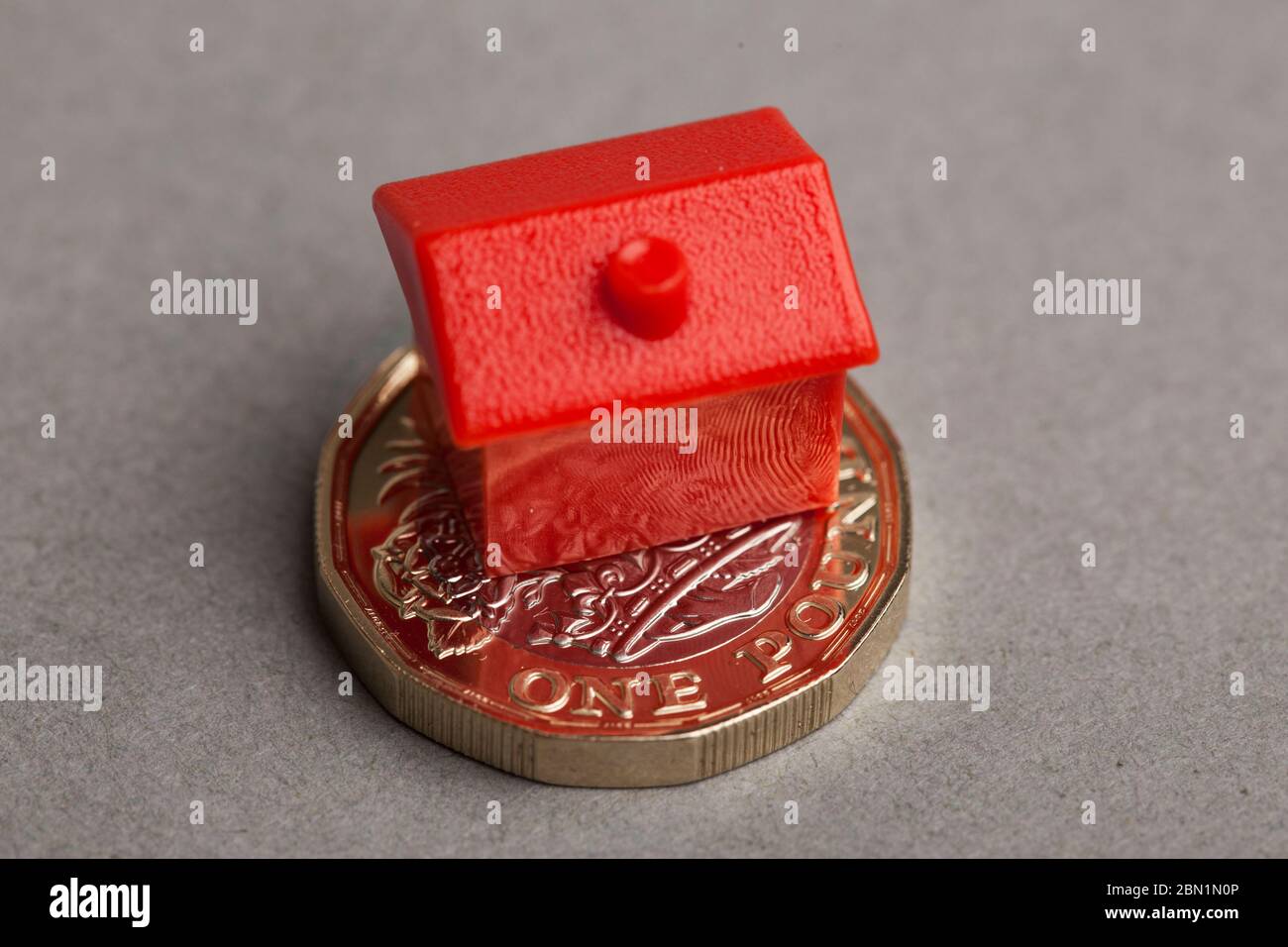 Red house on a british sterling one pound coin. Property price concept Stock Photo