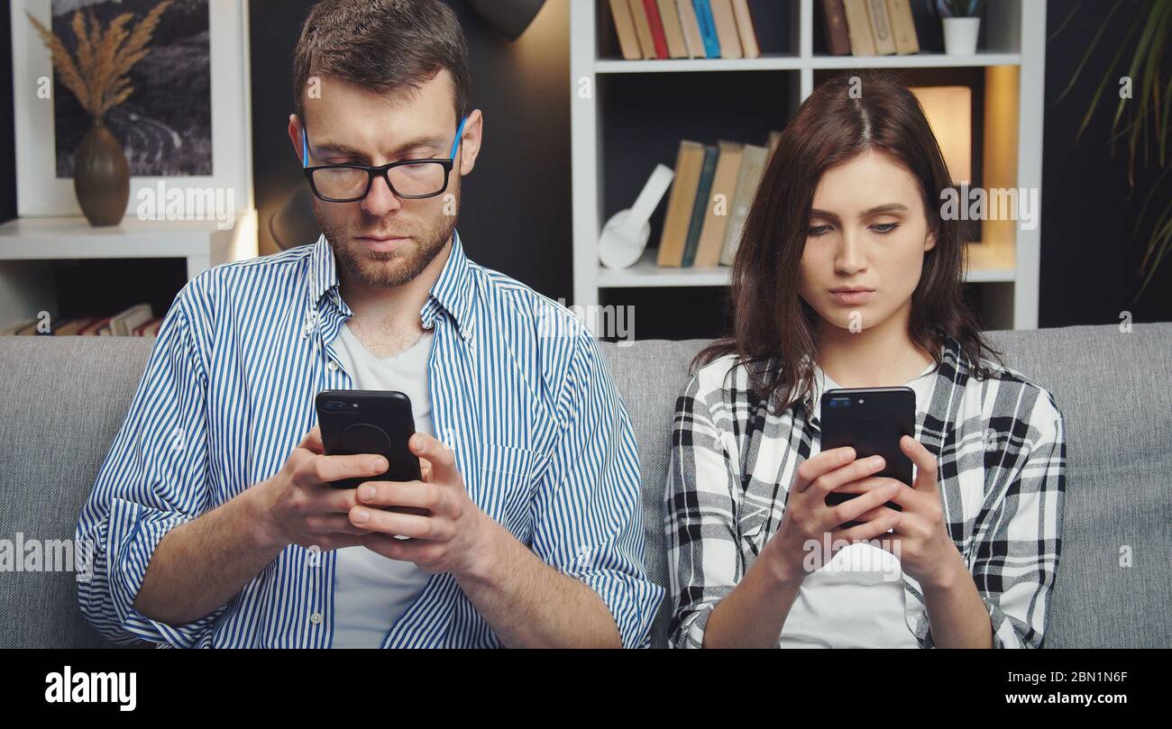 Spouses using their smartphones Stock Photo