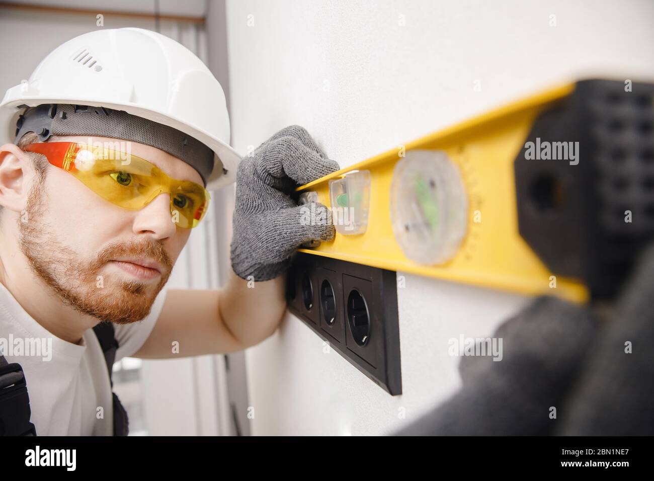 Electrician builder install working switches and sockets black color loft style. Stock Photo