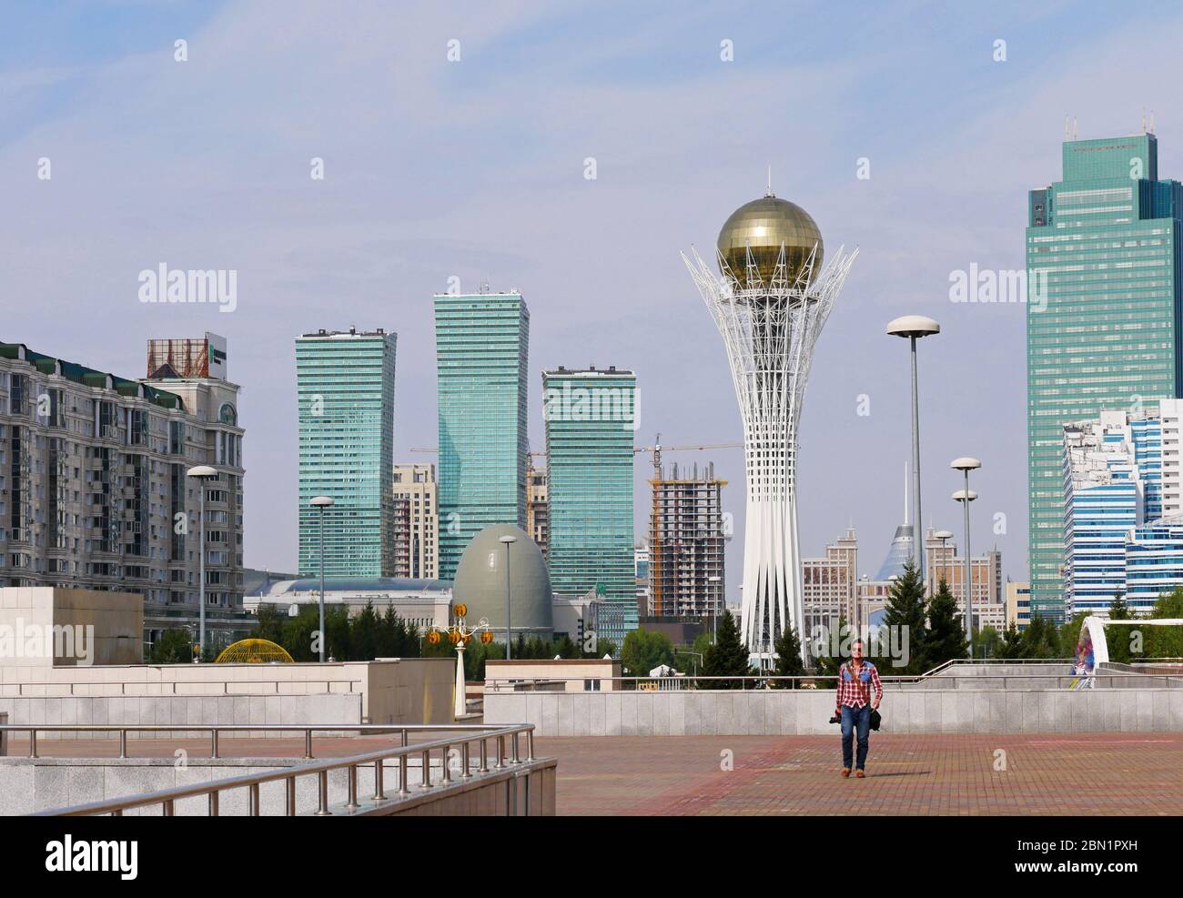 Man walking through Nur-Sultan (Astana) with the city skyline in the background Stock Photo