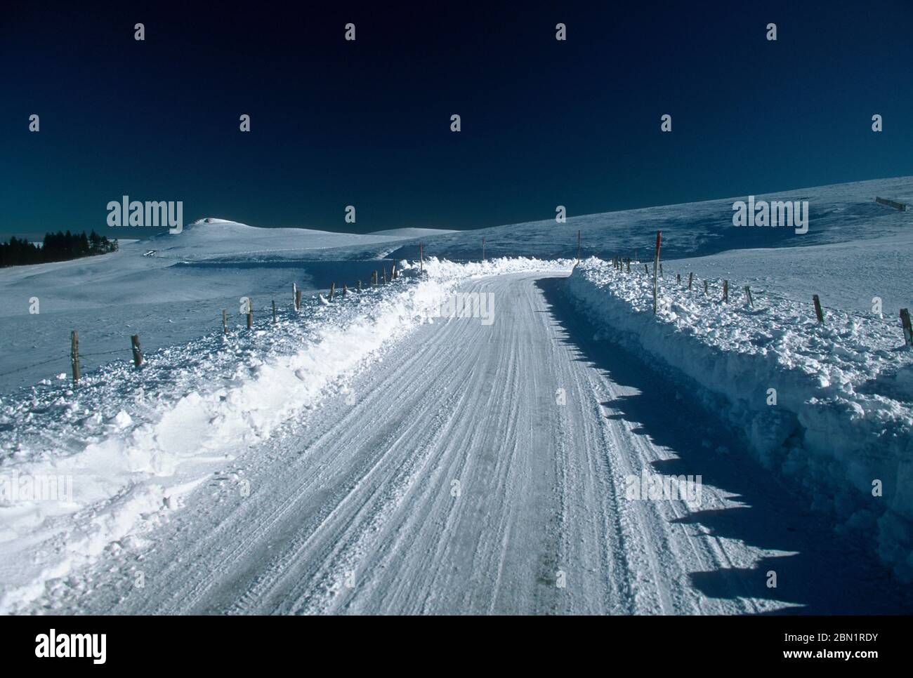 Frozen road in winter, Cezallier region, Auvergne-Rhone-Alpes, France Stock Photo