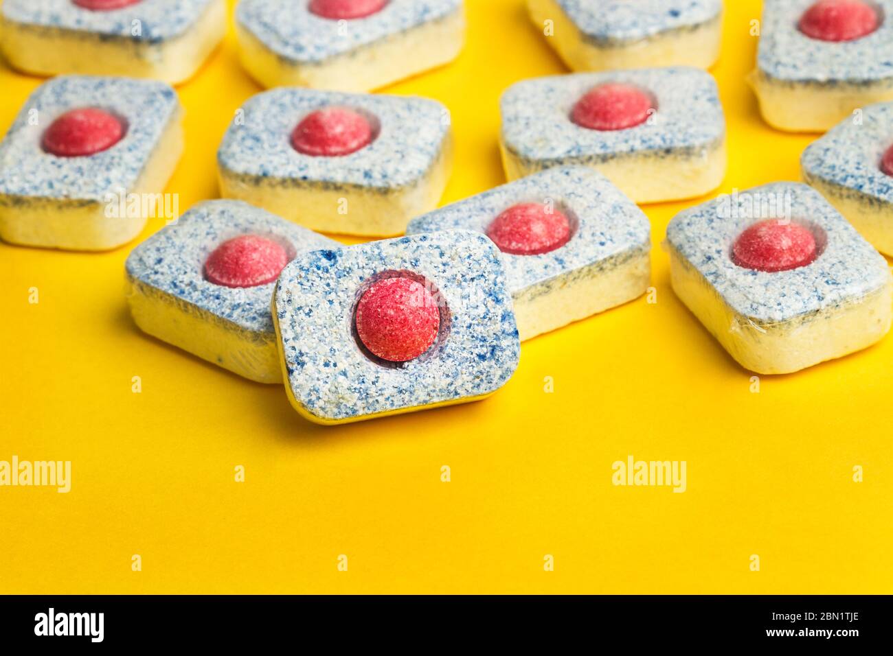 Dishwasher tablets on a yellow background Stock Photo