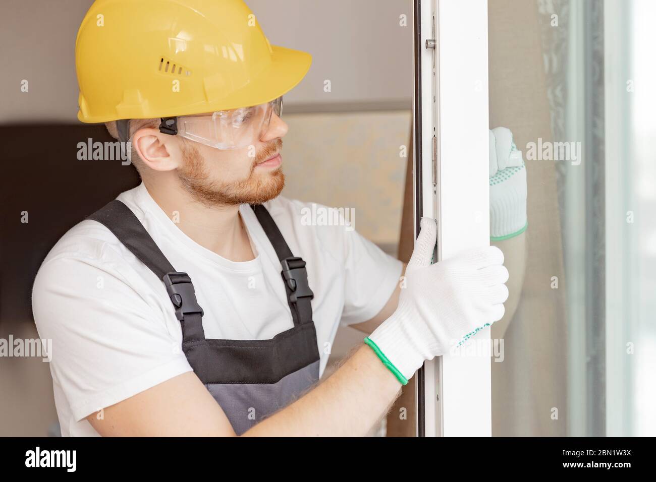 Worker in installing rubber seals on plastic upvc window Stock Photo