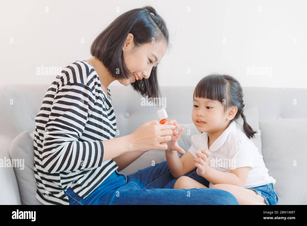 Mom paints nails to daughter Stock Photo Alamy