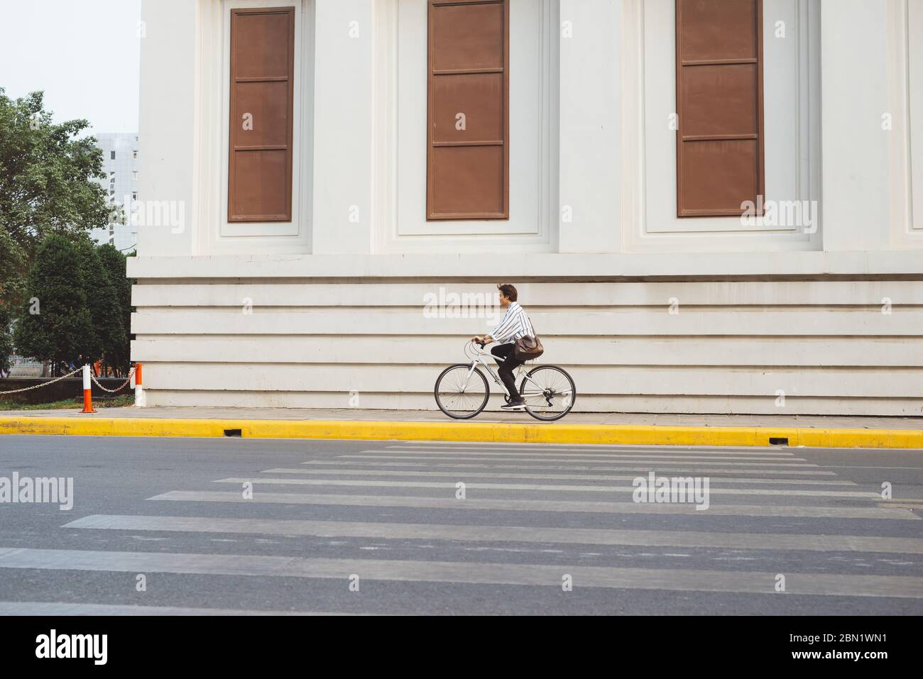 Going everywhere by his bike. Side view of young businessman looking forward while riding on his bicycle Stock Photo