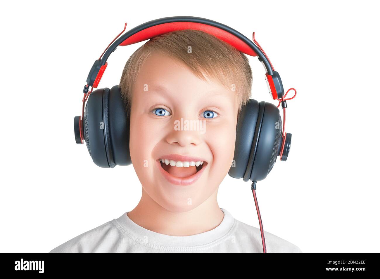 Closeup of an eight year old boy in headphones with wide opened eyes