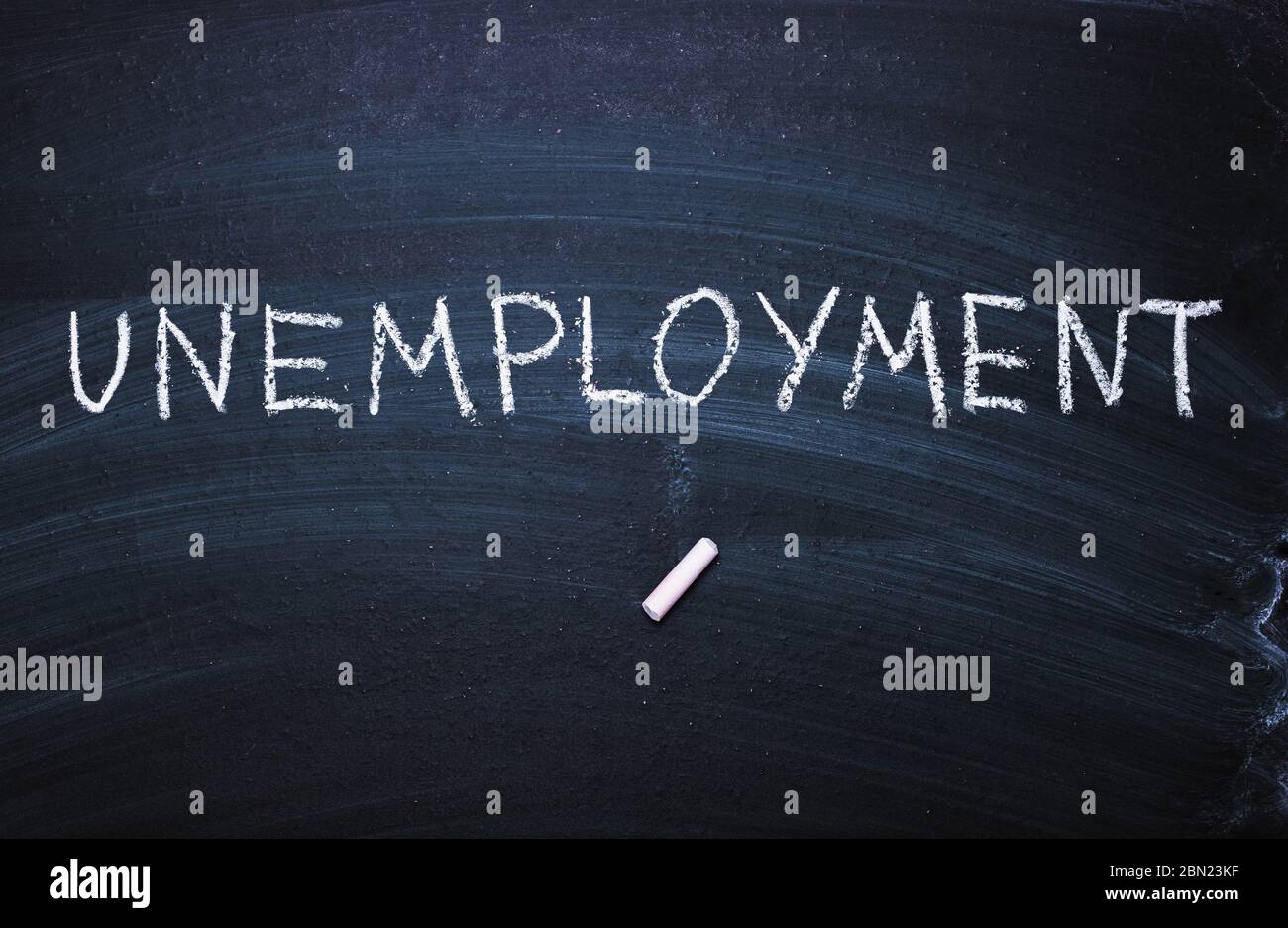 The word unemployment written in chalk. Concept of hiring, new job, vacancy, Stock Photo