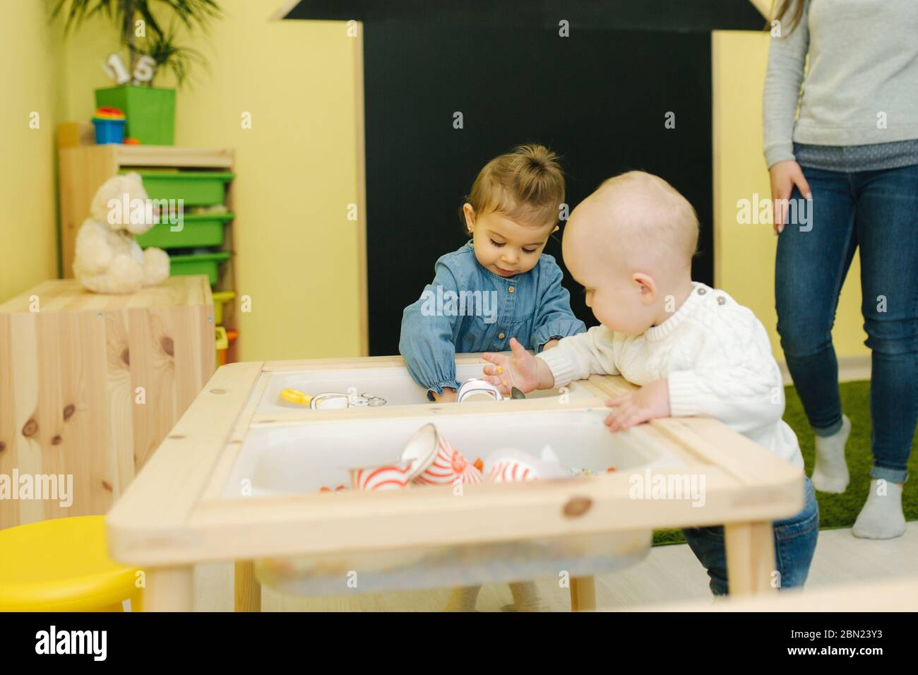 Cute kids one year old play together in nursery. Adorable little