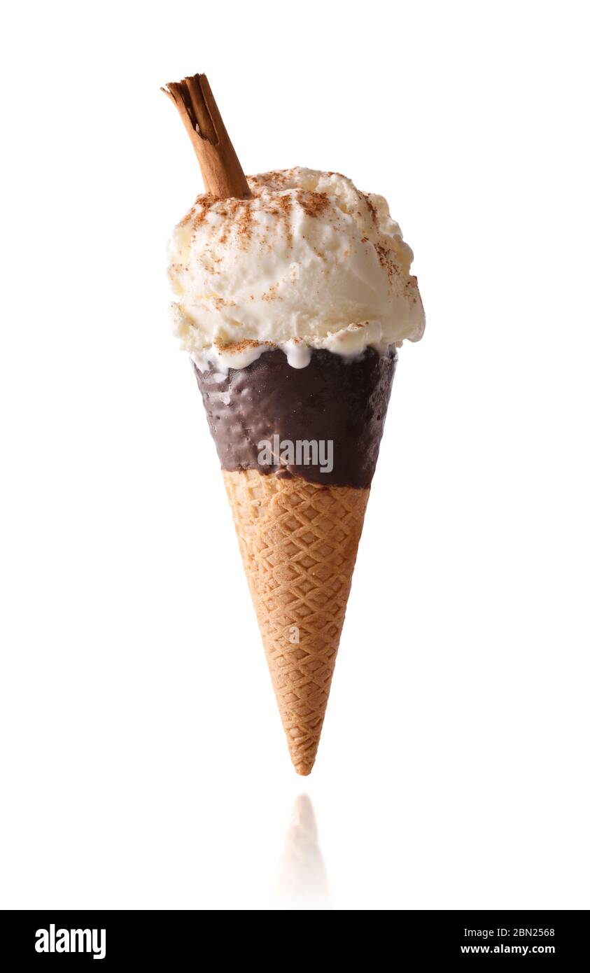 Meringue milk and cinnamon flavored cream ice cream with cinnamon stick isolated white background on semi-dipped chocolate cone Stock Photo