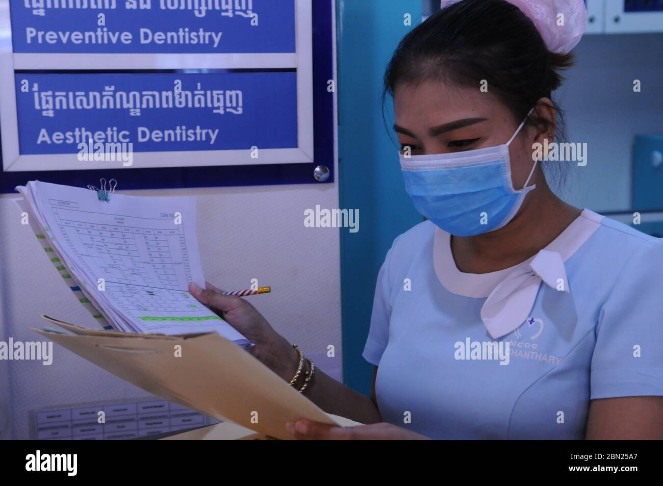 A Cambodian female dental assistant / receptionist, a front line worker