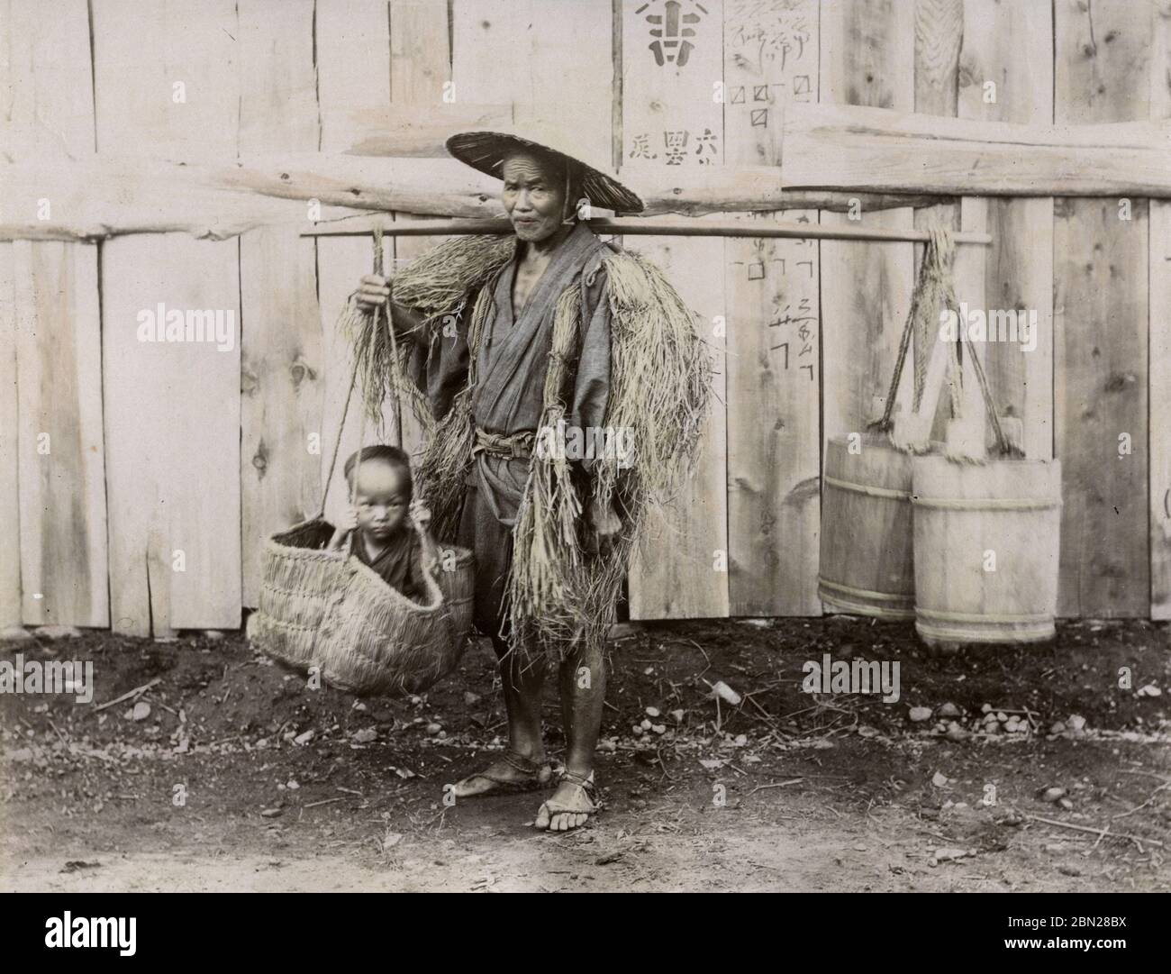 Japanese peasant man carrying child in a basket Stock Photo Alamy