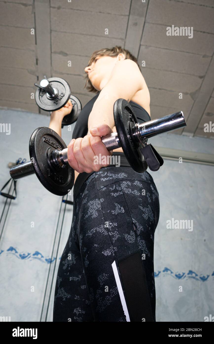 Young woman doing dumbbell arm exercise. Stock Photo