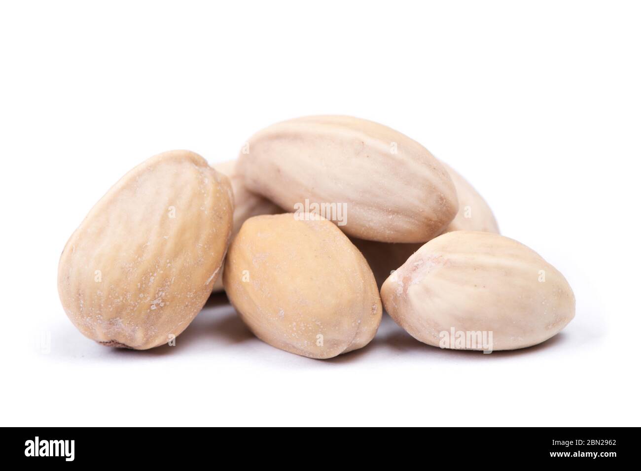Heap of closed unopened pistachios isolated on white background Stock