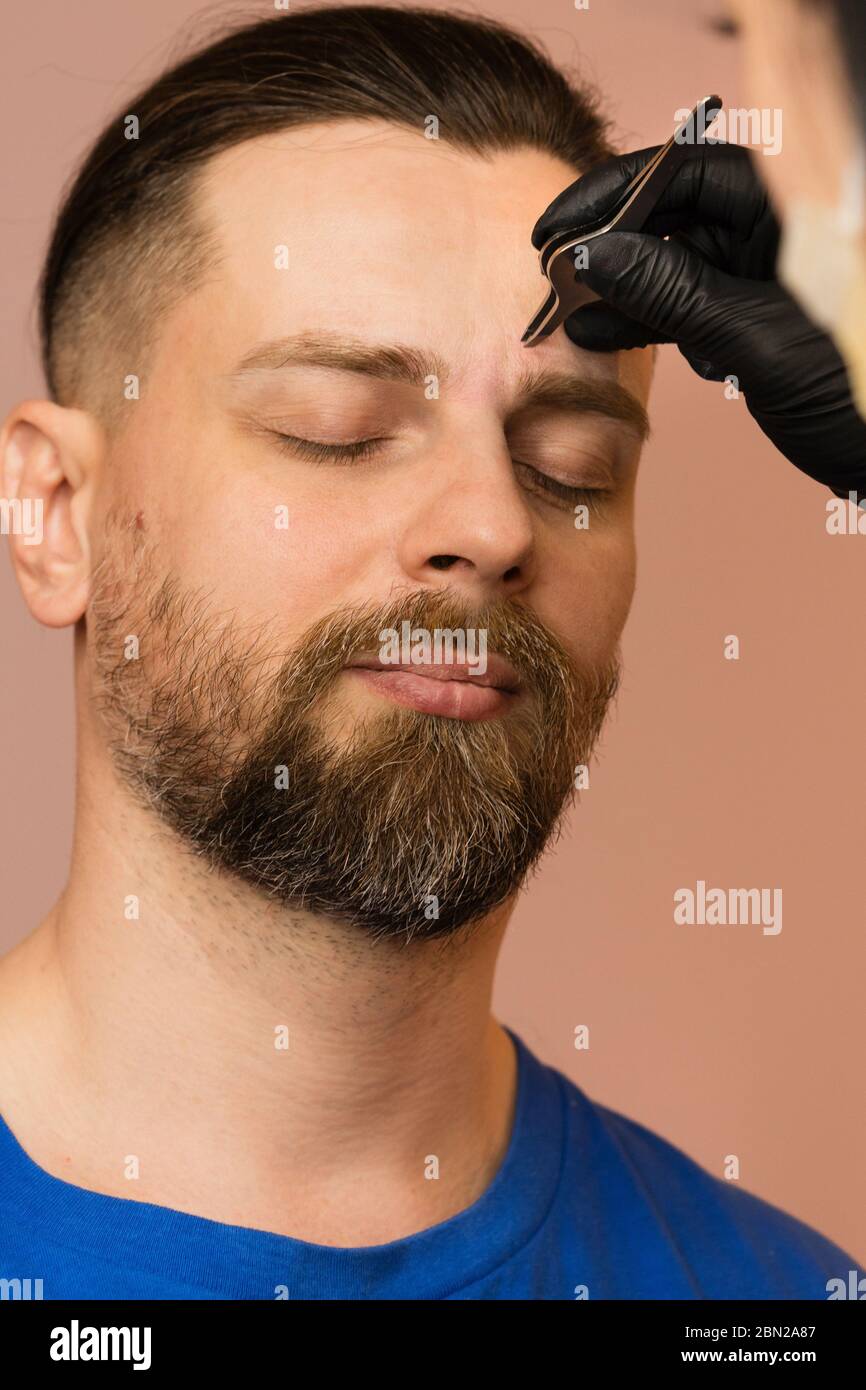 Professional barber doing threading procedure and correcting shape of