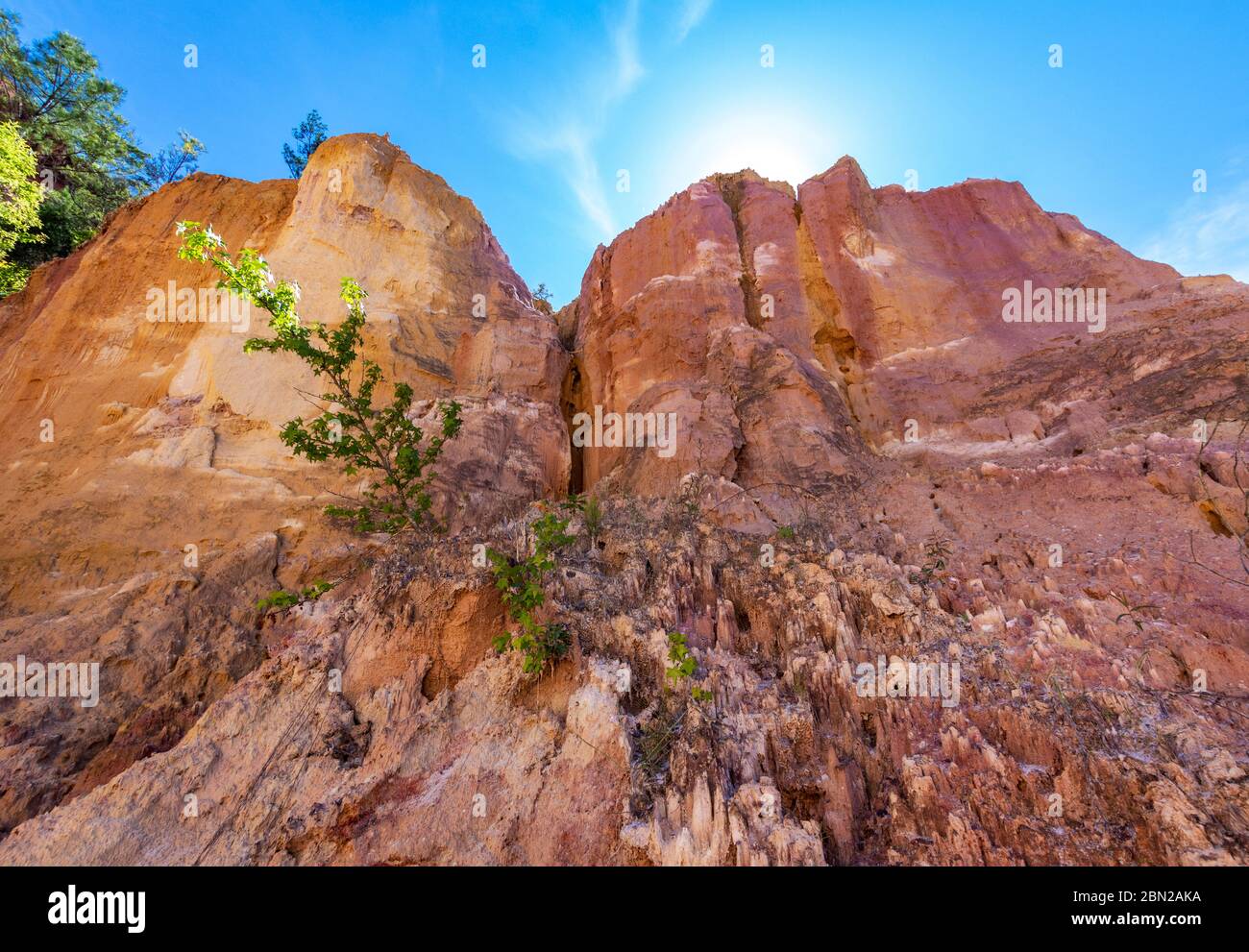 Sun rising behind the cliffs looking up from the canyon floor at Providence canyon Stock Photo