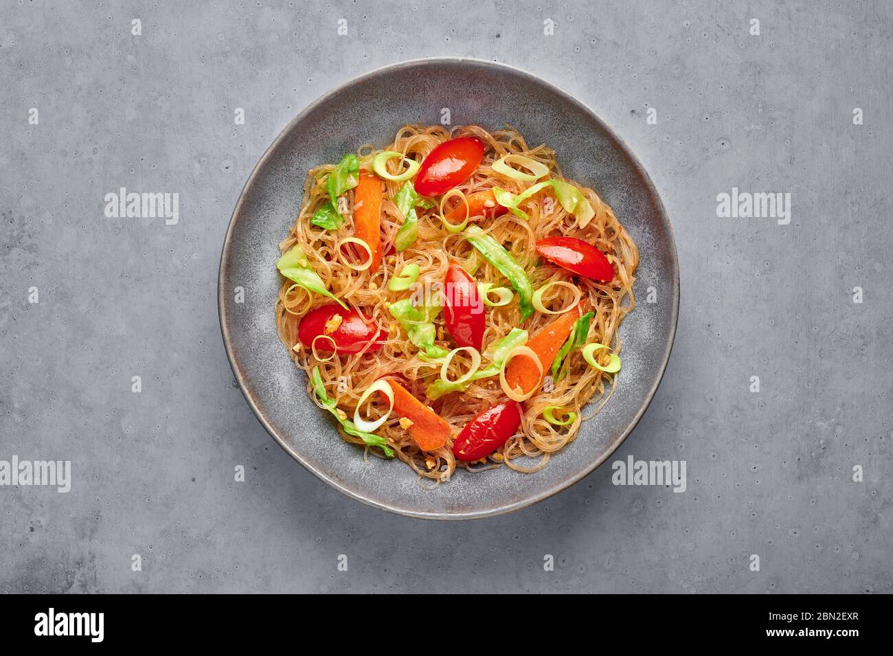 Veg Pad Woon Sen or Thai Glass Noodle Stir-Fry or Pad Thai in bowl on gray concrete backdrop. Vegetarian Pad Woon Sen is a Thai dish of glass bean noo Stock Photo