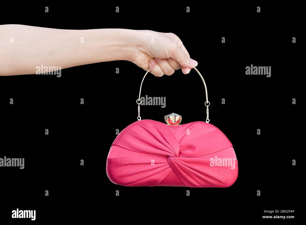 hand holding red luxury clutch bag isolated on black background. Stock Photo