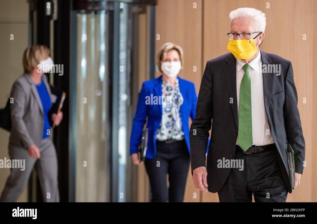 Stuttgart, Germany. 12th May, 2020. Winfried Kretschmann (r, Bündnis 90/Die Grünen), Prime Minister of Baden-Württemberg, followed by Baden-Württemberg's Minister of Economics Nicole Hoffmeister-Kraut (CDU) and Baden-Württemberg's Minister of Finance Edith Sitzmann (Bündnis 90/Die Grünen), goes to a government press conference. At the press conference, the state government announced new aid for medium-sized businesses. Credit: Christoph Schmidt/dpa/Alamy Live News Stock Photo