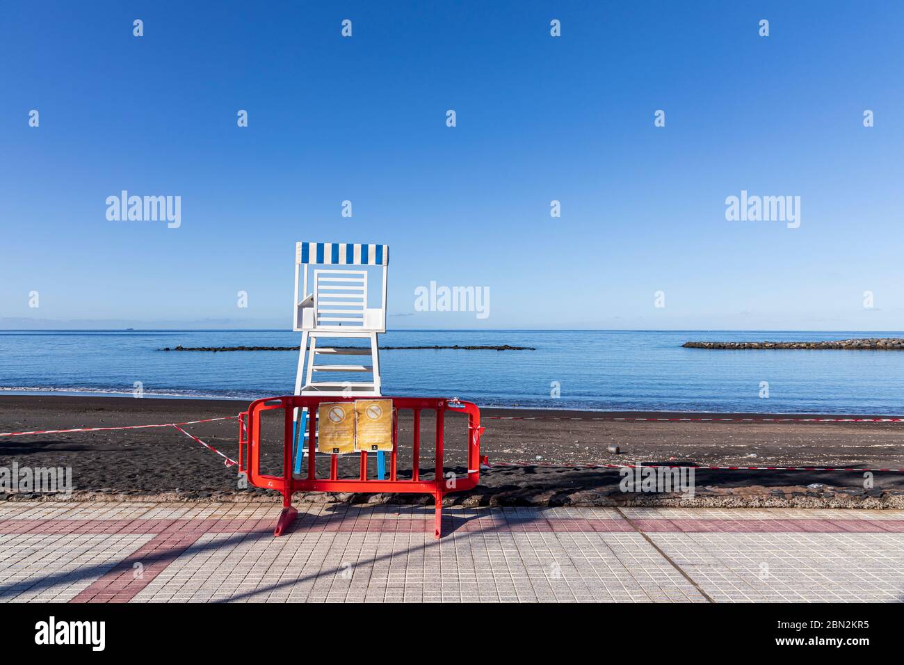 Barrier in front of lifeguard lookout tower on empty, deserted Playa Beril during coronavirus lockdown Costa Adeje, Tenerife, Canary Islands, Spain Stock Photo