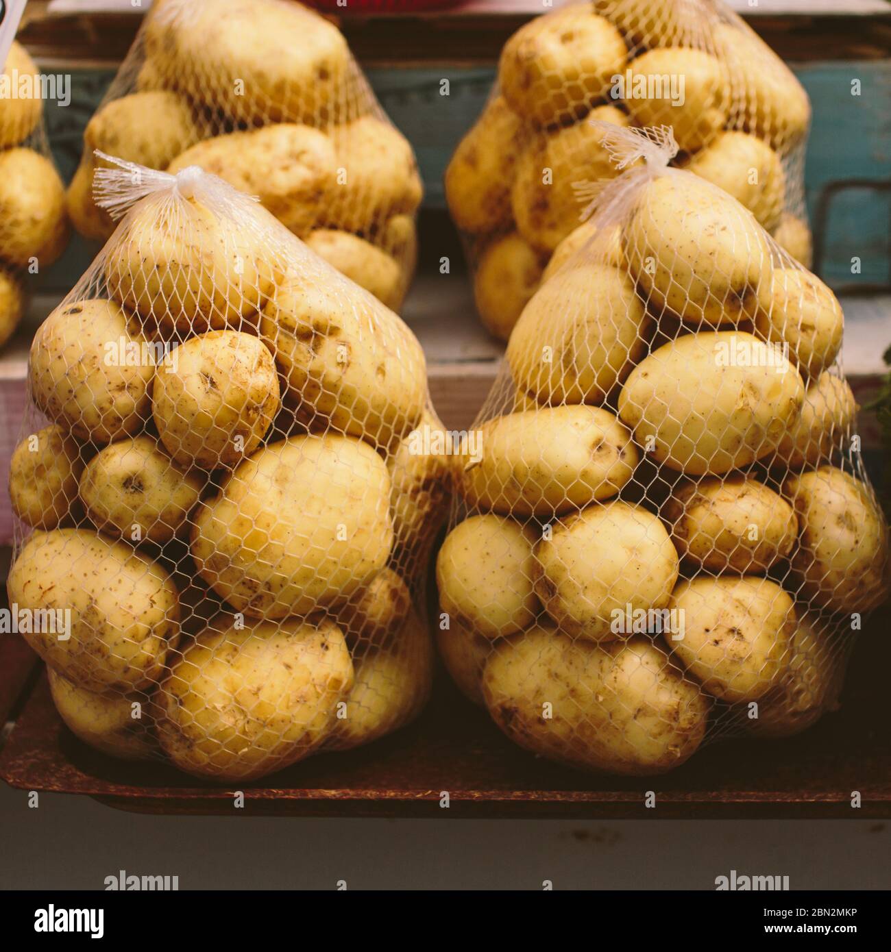 String bags with packaged fresh pure potatoes on a vegetable market ...