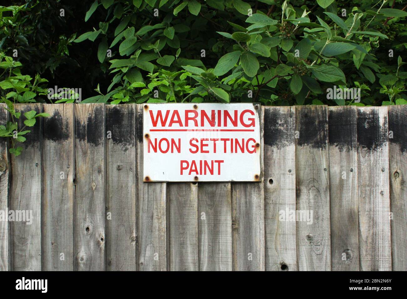A 'Warning, non setting paint' sign on an outdoor fence in Manchester, England Stock Photo